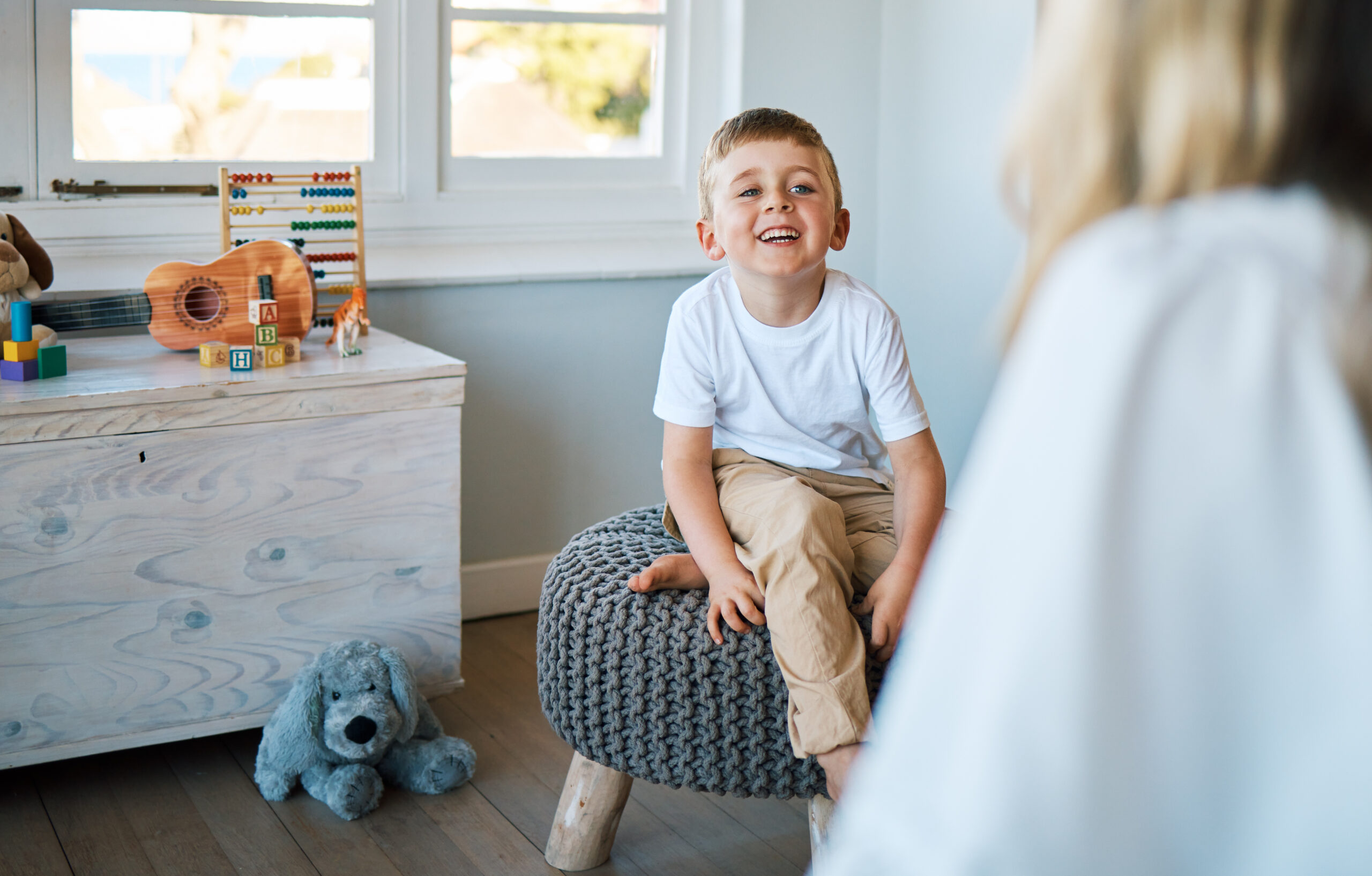 happy child sitting in his room talking to therapist