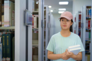 Student in a library carrying books