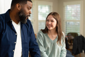 Father and daughter smiling at each other