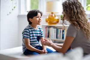 A youth in foster care smiling while interacting with their case manager.