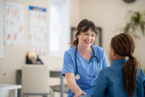 Smiling Missouri nurse communicating with a young girl.