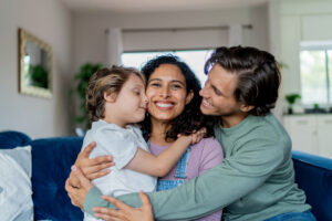 Parents embrace their child in a caring and supportive moment.
